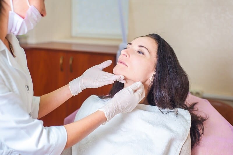 A botox nurse examining a women's lips